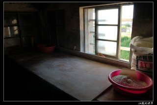 黃昏窗邊的光照射在數十年來老闆製作枕頭餅的平台，一樣的平台、一樣的人物卻有不一樣的痕跡